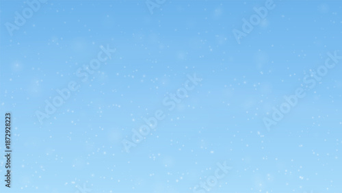 Gentle snowfall on light blue winter background