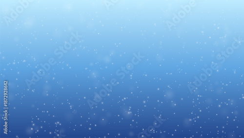 Gentle snowfall over soft light blue winter background