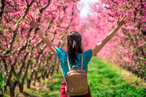 Young woman in the blooming peach field