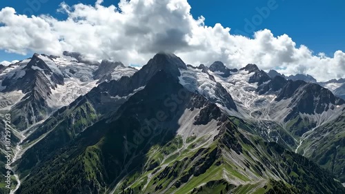 Majestic mountain range with glaciers under a partly cloudy sky during daytime