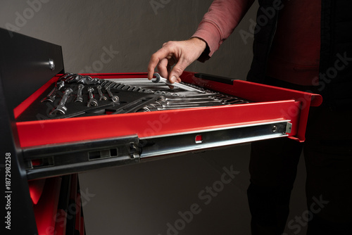 Принти на полотні Hand selecting wrench from organized tool drawer