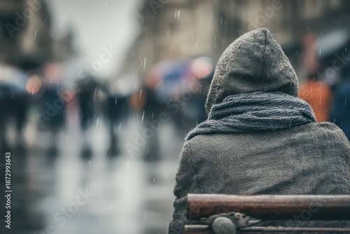 homeless man is sitting on the bench in front of the city center