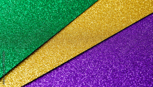 Close-up of overlapping shimmering textured surfaces in Mardi Gras colors, sharply focused and under bright studio lighting.