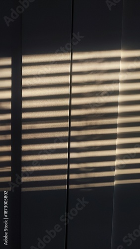 Sunlight streaming through window blinds creates dramatic striped light and shadow patterns on a dark interior surface, forming a cinematic and atmospheric scene.