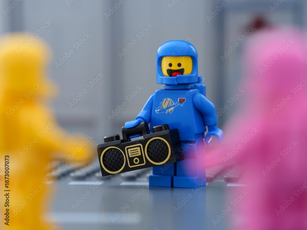 Obraz premium Tambov, Russian Federation - May 30, 2025 Blue Lego astronaut minifigure holding a boombox standing next to two other Lego cosmonauts