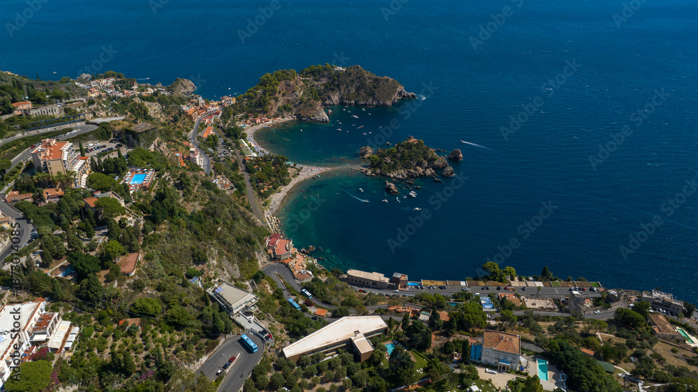 Obraz premium Aerial view of Isola Bella, in Sicily, Italy. It is an Italian tidal island located in the Ionian Sea, near Taormina. It is a nature reserve in the Mediterranean Sea. It is a sunny summer morning.
