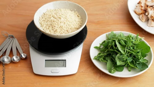 Measuring ingredients: hands prepare salad with lettuce, mushrooms, grains on scale in kitchen