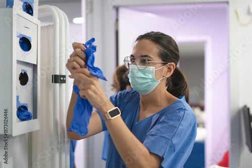 Valokuva Nurse wearing medical mask preparing blue sterile gloves
