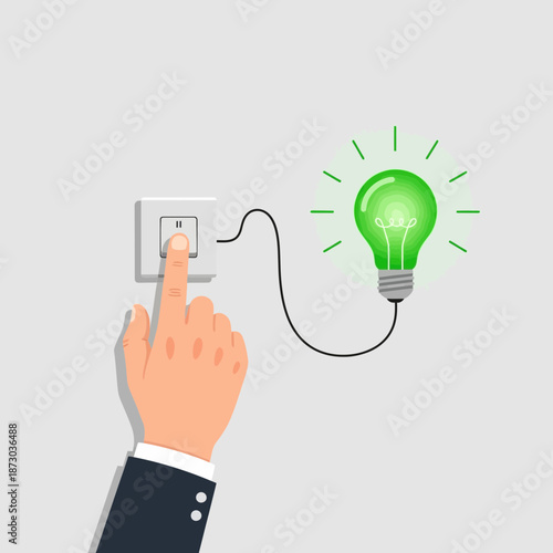 Hand flipping a light switch with a green glowing light bulb on a cord