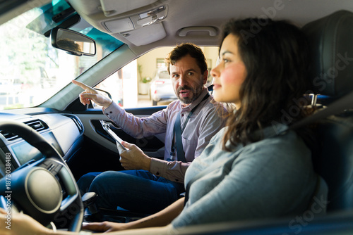 Canvastavla Driving instructor teaching adult woman student during a practical lesson inside