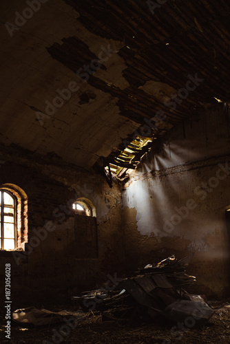 Abandoned interior of a dilapidated church building with shafts of light illuminating debris and walls
