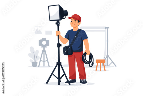 Young asian male photographer setting up studio lighting equipment