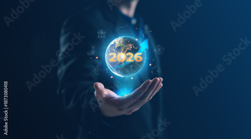 Businessman presenting a digital globe with 2026 highlighted, symbolizing future planning, global strategy, financial growth, and technology driven business vision in a modern corporate environment.