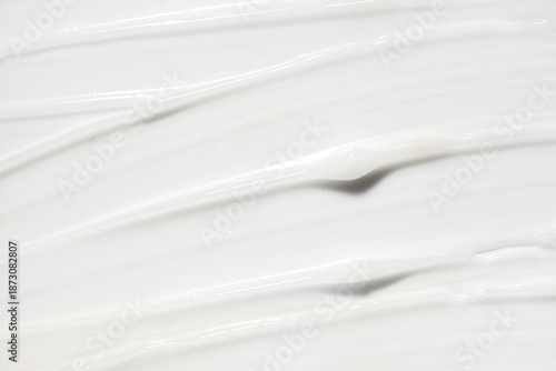 Cosmetic beauty product silky cream texture beige milky white colored background