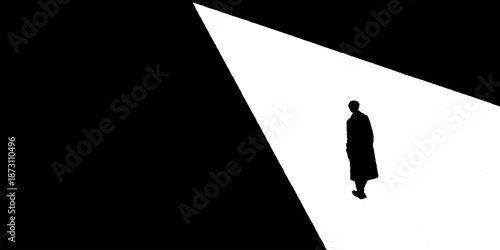 Silhouette of a solitary figure walking in high-contrast black and white light