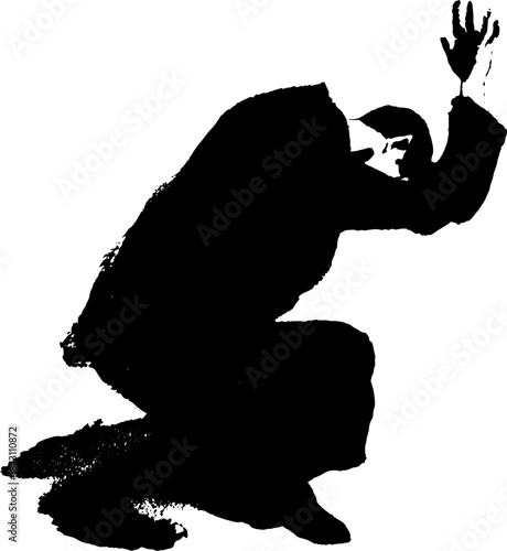 Silhouette of kneeling male in prayer or despair