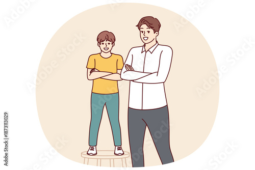 Father and son smiling standing with arms crossed and looking at screen for concept of intergenerational succession and parenthood. Little boy stands on stool near father or older brother