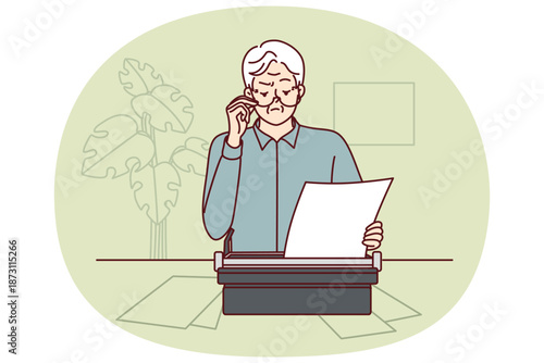 Elderly man uses typewriter and works as writer, wanting to publish own book of fiction. Gray-haired pensioner stands at table with papers and typewriter using old-fashioned typing equipment