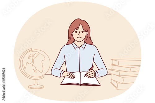 Teenager girl sits at school desk with globe and books to gain new knowledge and quality education. Schoolgirl studying in elementary school is happy to do homework given by teacher in geography