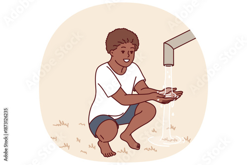 African boy sits near clean water faucet, rejoicing at opportunity to quench thirst during drought. Child drinks and draws water in palm of hand to drink, for concept acosania helping children Africa
