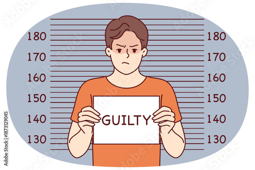 Man criminal with inscription guilty on sign stands near lines for measuring height of arrested bandit. Guilty guy who committed crime is detained by police and needs help of lawyer for court hearing