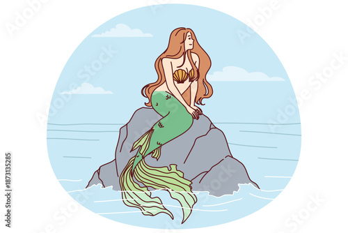 Mermaid sits on sea rock to illustrate fairy tales about ocean dwellers and magical creatures living underwater. Beautiful mermaid girl with fish tail and shell bra looks to side in search of ships