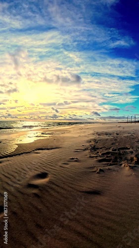 Calm Ocean Shoreline at Sunset with Soft Waves and Cloudy Sky