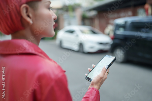 Traveler Gen z girl leather fashion with punk Asian woman tourist in city street searching location in map application online smart phone using GPS navigating