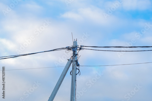 Russia, Saint Petersburg, 11.01.2026 Concrete utility pole with power lines and communication cables against a blue sky. Energy infrastructure and distribution concept.