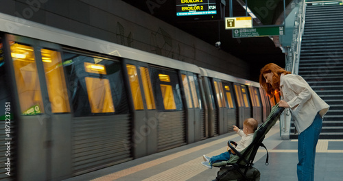 Woman with child waits on subway platform during urban travel