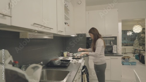 A warm and inviting kitchen scene where a person is engaged in cooking. The space is modern, well-lit, and reflects a cozy ambiance, ideal for home-cooked meals and gatherings.
