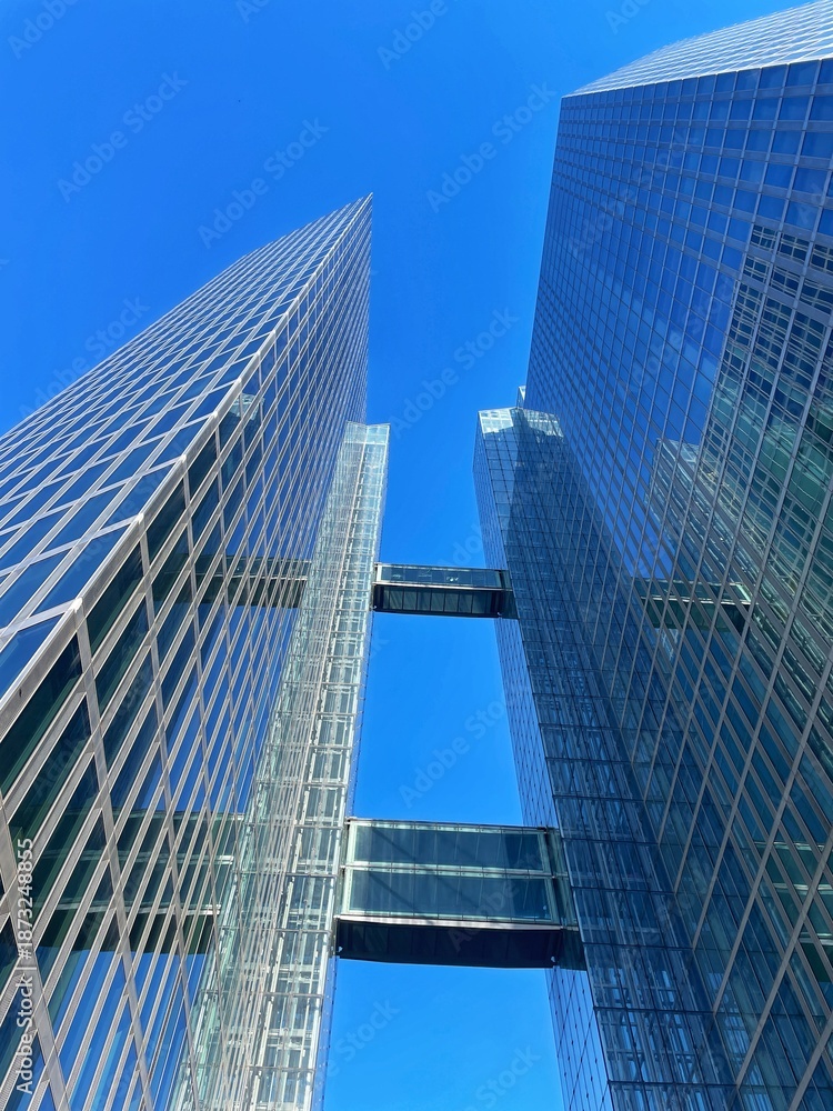 Obraz premium Modern Glass Skyscrapers with Skybridges Against Clear Blue Sky