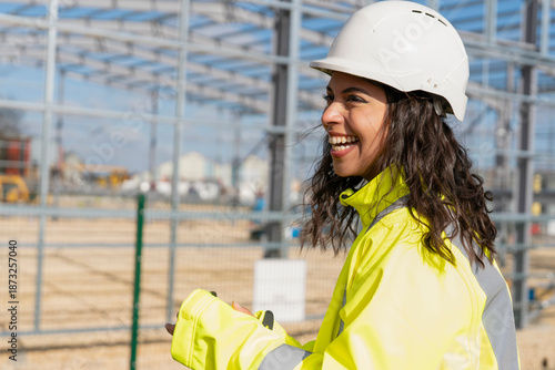Canvas Print Happy smiling femail builder in hard hat and hi-viz fluorescent safety jacket in