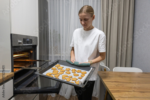 Young woman enjoying the aroma of fresh pastry in a modern kitchen