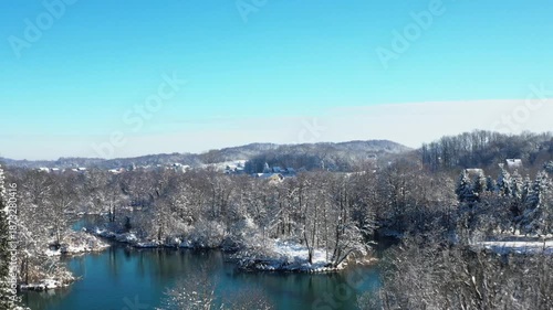 Mreznica River in Croatia, snow on river banks, waterfalls and tree branches, idyllic rural winter landscape
