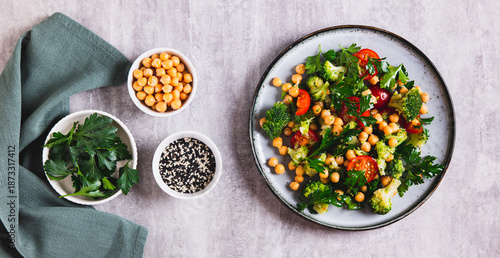 Mix of chickpeas, tomatoes, broccoli and parsley on a plate on the table top view web banner