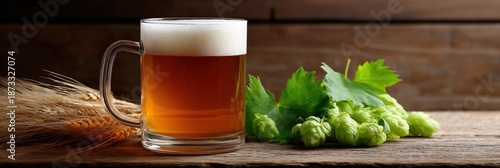 Glass of amber beer with hops and barley on rustic wooden table