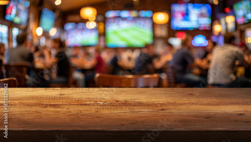 blurred busy interior of sports bar and wooden countertop in foreground
