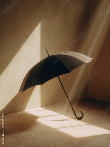 Closed umbrella stands gracefully in a sunlit interior space with soft shadows