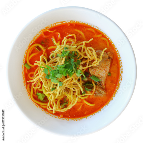 Thai chicken yellow noodle soup in white bowl isolated on white.