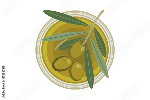 A bowl of olive oil with green olives and a leafy branch