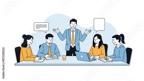 Professional business team gathers around a conference table for a meeting while a male leader stands and gestures during his presentation.