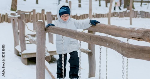 Child Navigating Snowy Playground Obstacle Course in Winter