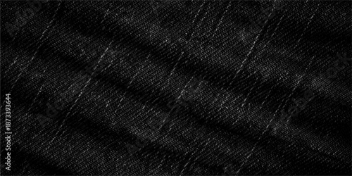 A closeup of dark black leather and rough cotton denim fabric texture reveals a patterned textile surface ideal for a fashion material background or clothing design wallpaper