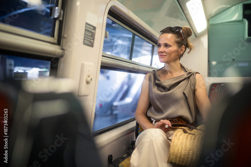Foto A confident woman with sunglasses on her head looks relaxed gazing out a train window during her city break