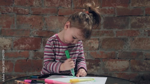 Little girl portrait while painting with felt-tip pen on block paper isolated