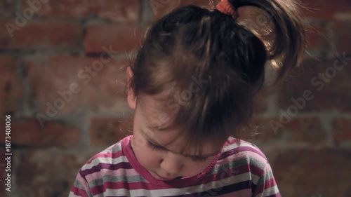 Toddler girl portrait while painting with felt-tip pen on block paper, tilt down to hands