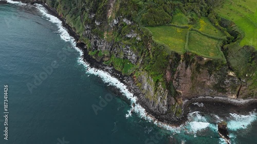 Rugged volcanic shoreline with fertile green landscapes on top of coastal cliffs, Sao Miguel Island, Azores