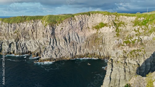 Massive volcanic cliffs rising above the Atlantic with soft golden-hour light at Cape Cintrao, Azores. Aerial view