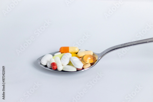 Colorful Pills and Capsules on a Spoon, Medicine and Dietary Supplement Concept.